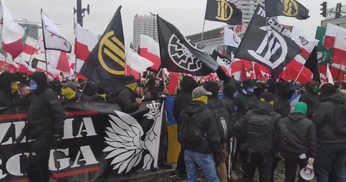 Učesnici marša nose transparent sa simbolom "Crno sunce" garde nacističke Njemačke - Avaz